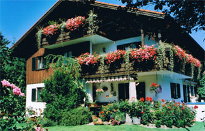 Das Haus im Sommer mit Blumen am Balkon